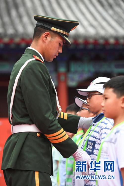 7月11日,天安门国旗护卫队战士在纠正香港小学生的站姿.